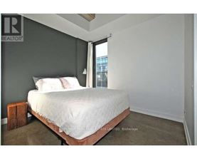 A bedroom with a bed, pillows, and a nightstand.