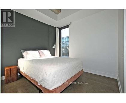 A bedroom with a bed, pillows, and a nightstand.