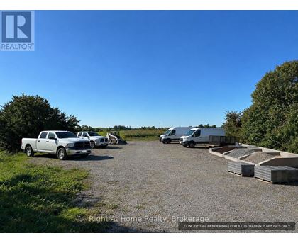 A gravel lot with a truck, a van, and a trailer.
