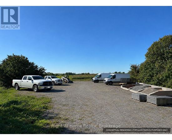 A gravel lot with a truck, a van, and a trailer.