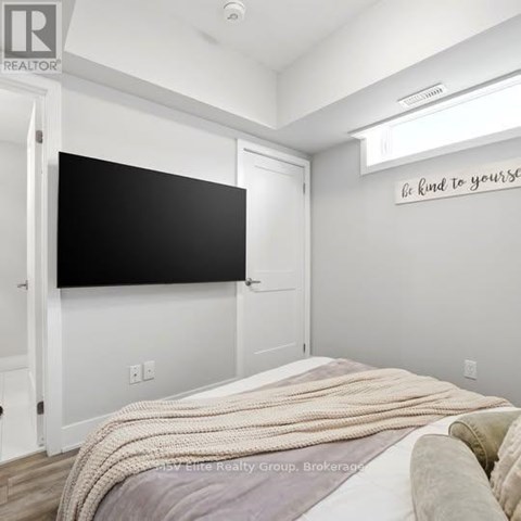 A bedroom with a bed covered in a blanket and a blackboard on the wall.