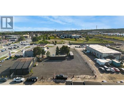 An aerial view of a parking lot with a building and cars.