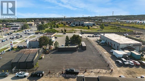 An aerial view of a parking lot with a building and cars.