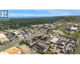 An aerial view of a commercial area with a parking lot and buildings.