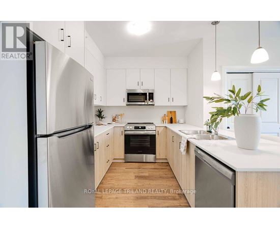 A modern kitchen with stainless steel appliances and wooden cabinets.