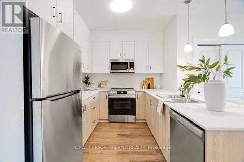 A modern kitchen with stainless steel appliances and wooden cabinets.