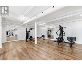 A gym with a mirror, weights, and exercise equipment.