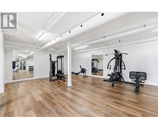 A gym with a mirror, weights, and exercise equipment.