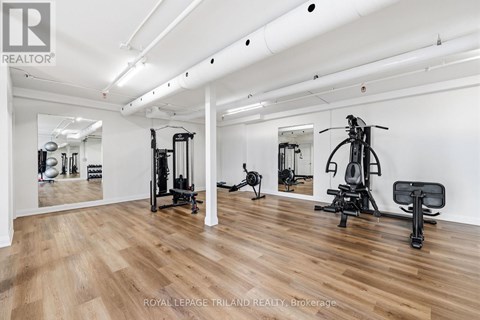 A gym with a mirror, weights, and exercise equipment.