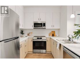 A modern kitchen with a refrigerator, oven, microwave, and cabinets.