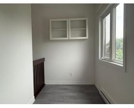 A room with a window and a cabinet above it.