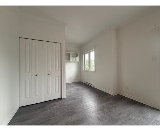 A room with a slanted ceiling and a large white door.