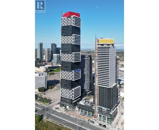 A tall building with a red roof is under construction in a city.