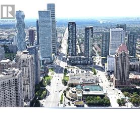 A cityscape with a mix of modern and older buildings, a large open square, and a clear sky.