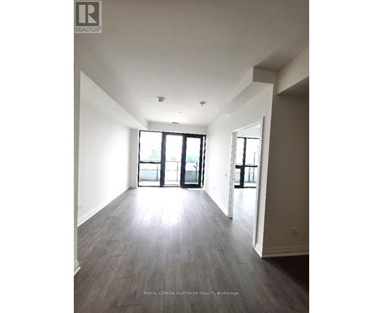 A spacious room with a large window and sliding glass doors.