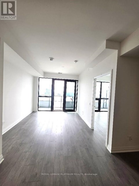 A spacious room with a large window and sliding glass doors.