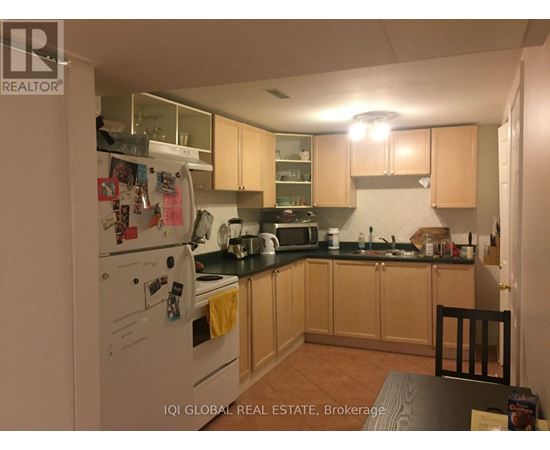 A kitchen with a white fridge and wooden cabinets.