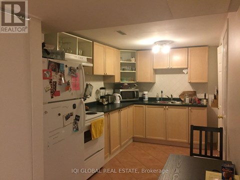 A kitchen with a white fridge and wooden cabinets.