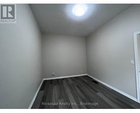 A room with wooden flooring and white walls.