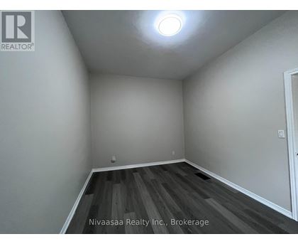 A room with wooden flooring and white walls.