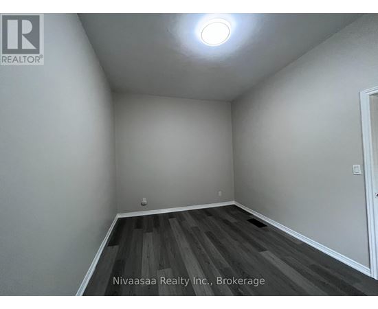 A room with wooden flooring and white walls.