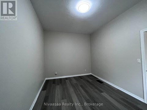 A room with wooden flooring and white walls.