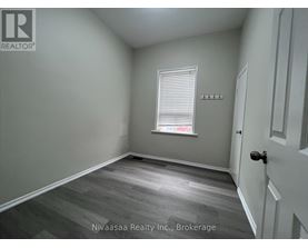 A room with a door, a window with blinds, and a wall with a logo.