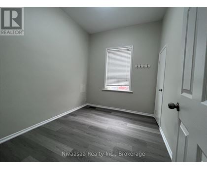 A room with a door, a window with blinds, and a wall with a logo.