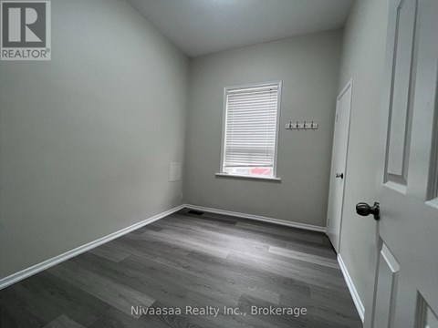 A room with a door, a window with blinds, and a wall with a logo.