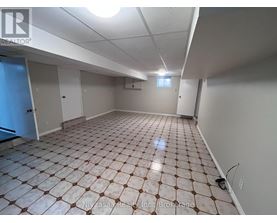 A spacious room with a tiled floor and white walls.