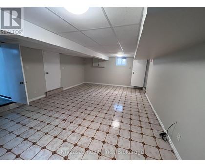 A spacious room with a tiled floor and white walls.