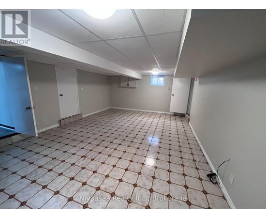 A spacious room with a tiled floor and white walls.