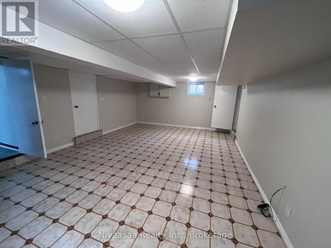 A spacious room with a tiled floor and white walls.