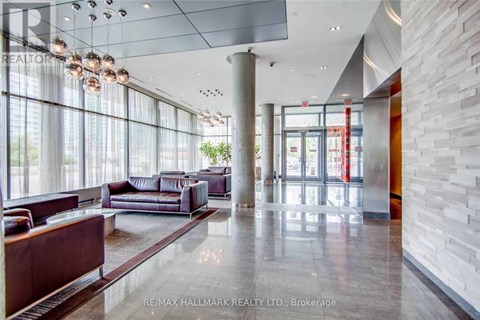 A spacious lobby with a marble floor and a large window.