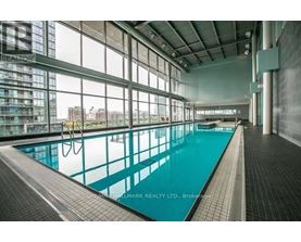 A large indoor swimming pool with a tiled floor and walls.
