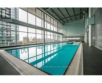 A large indoor swimming pool with a tiled floor and walls.