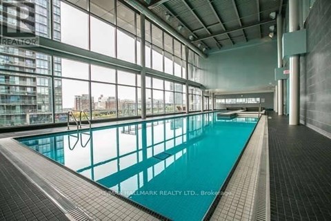 A large indoor swimming pool with a tiled floor and walls.
