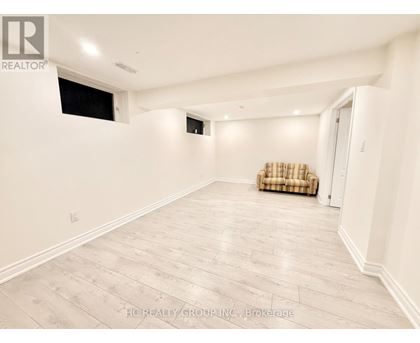 A spacious room with a couch and a window.