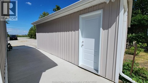 A white door is on the side of a building.