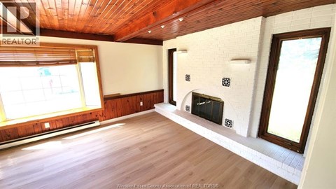 A living room with a fireplace and a large window.