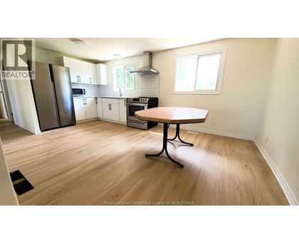A kitchen with a table and a refrigerator.