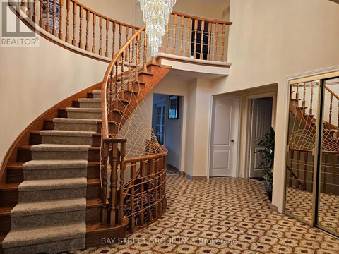 A staircase with a wooden banister and a chandelier hanging from the ceiling.