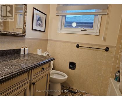 A bathroom with a toilet, a counter, and a window.
