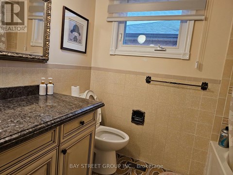 A bathroom with a toilet, a counter, and a window.