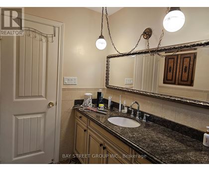 A bathroom with a sink, mirror, and light fixture.