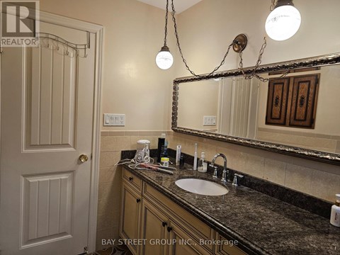 A bathroom with a sink, mirror, and light fixture.
