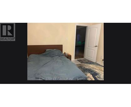 A bedroom with a bed and a doorway leading to another room.