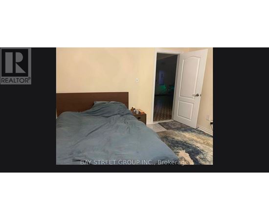 A bedroom with a bed and a doorway leading to another room.