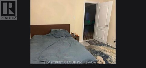 A bedroom with a bed and a doorway leading to another room.