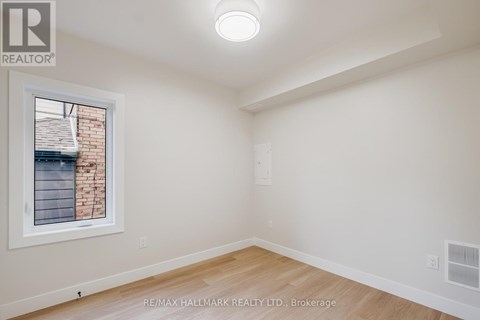 A room with a window and a wooden floor.